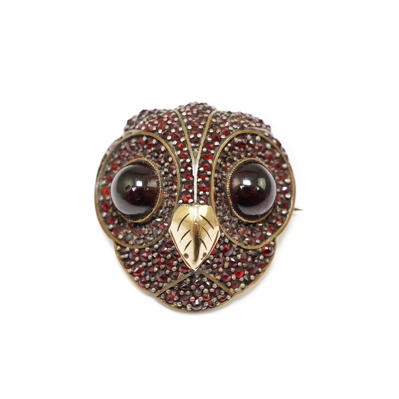 A Victorian gold overlaid base metal and pave set garnet owl's head brooch